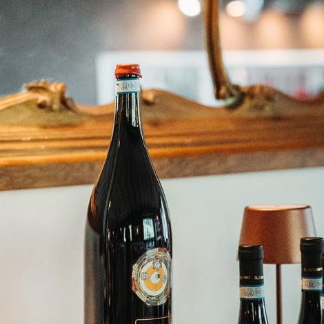Fara wine bottle on a log, elegant and sophisticated atmosphere.