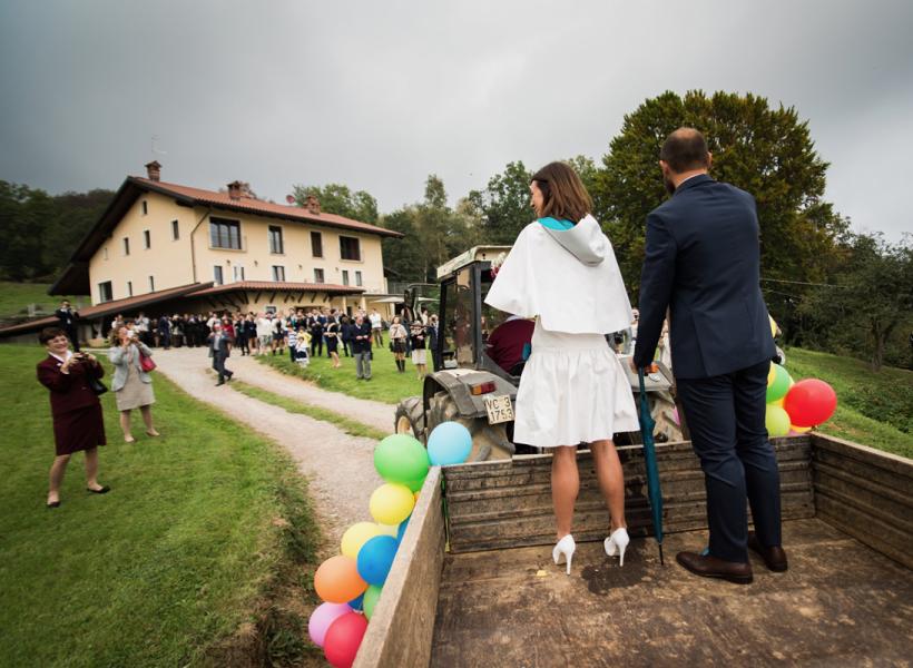 Couple on decorated cart, outdoor celebration, joyful and festive atmosphere.