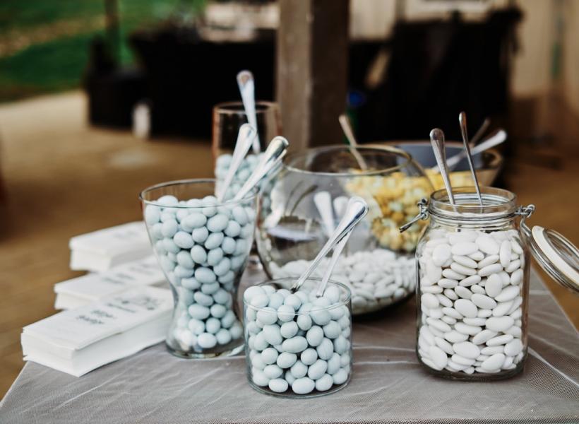Colorful sugared almonds in elegant glass jars, ready for a sweet celebration.