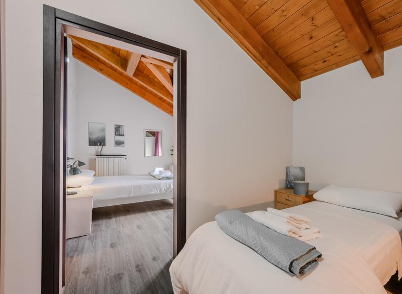 Cozy room with warm wood and fresh linens, serene atmosphere.