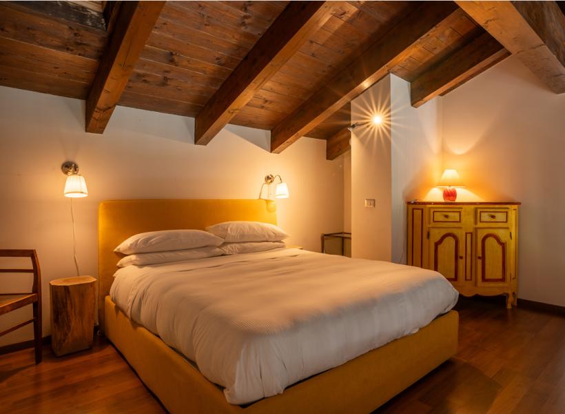 Cozy room with yellow bed, warm wood, and soft lighting.