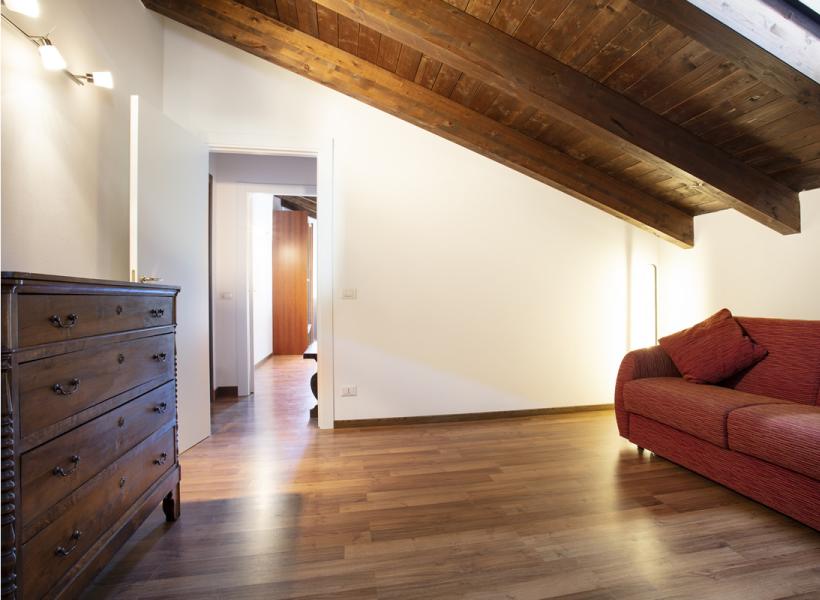 Cozy living room with wooden ceiling and red sofa.