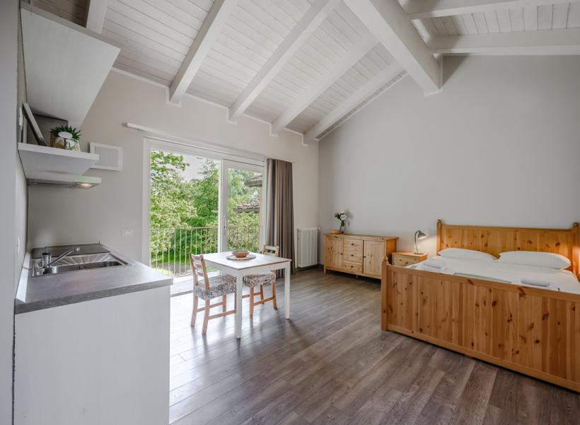 Bright room with wooden furniture, green view, and cozy ambiance.