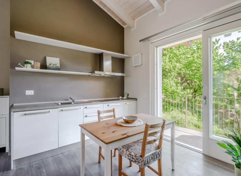 Bright kitchen with wooden table, overlooking relaxing greenery.