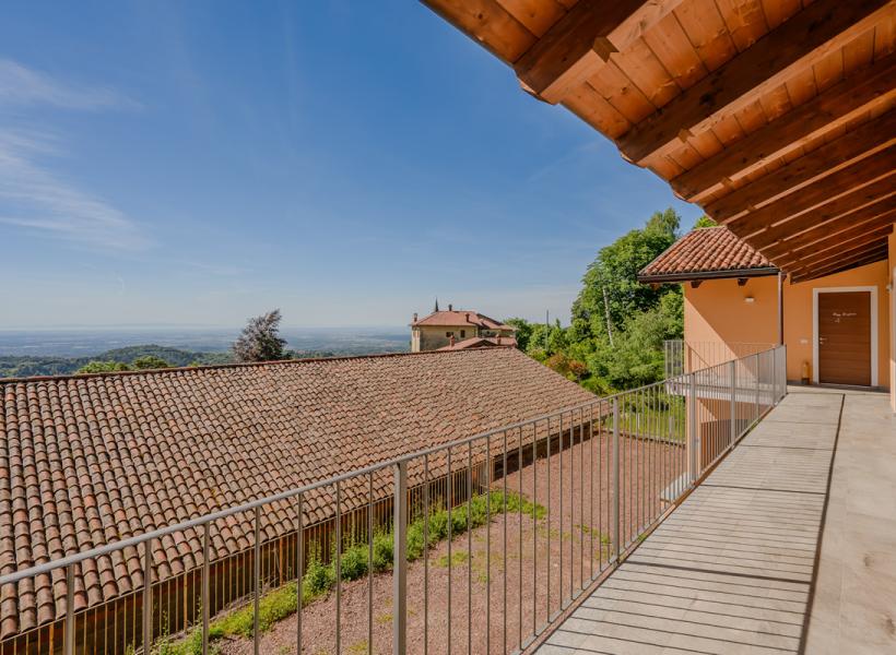 Panoramic view of green hills and blue sky from a sunny terrace.