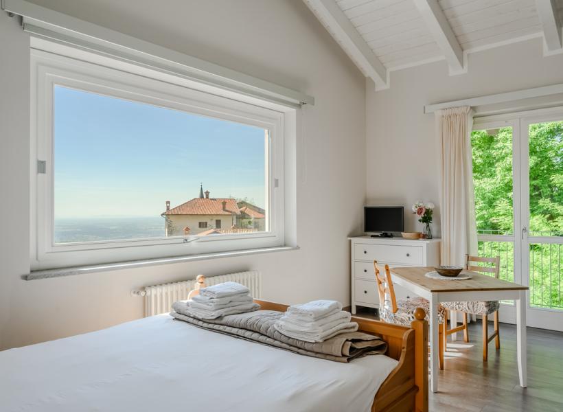 Bright room with breathtaking view, cozy decor, and lush nature.