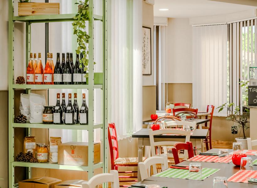 Cozy restaurant with wines, colorful decorations, and a warm atmosphere.