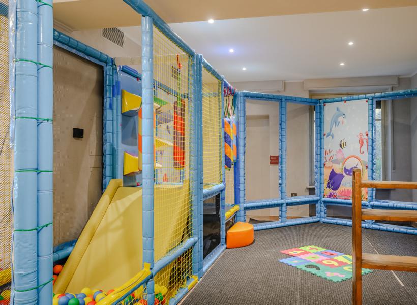 Colorful play area with slide, balls, and marine decorations, cheerful atmosphere.