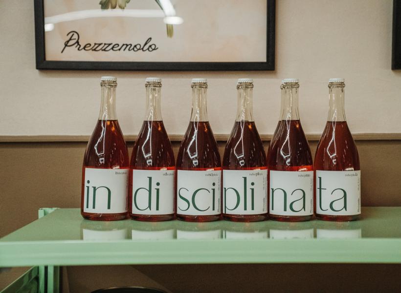 Rosé wine bottles with labels spelling 'indisciplinata'.